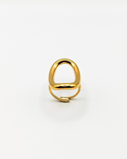 Anello Altea in acciaio inossidabile color oro. È fotografato rivolto verso l'alto e si notano sia l'ovale traforato che si trova sulla parte superiore, sia la chiusura regolabile sul retro.
