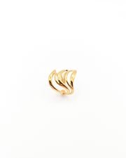 Anello Giulia in acciaio inossidabile color oro. È fotografato rivolto verso l'alto. Si vede il design a onde con il ricciolo sul lato inferiore, verso la chiusura.