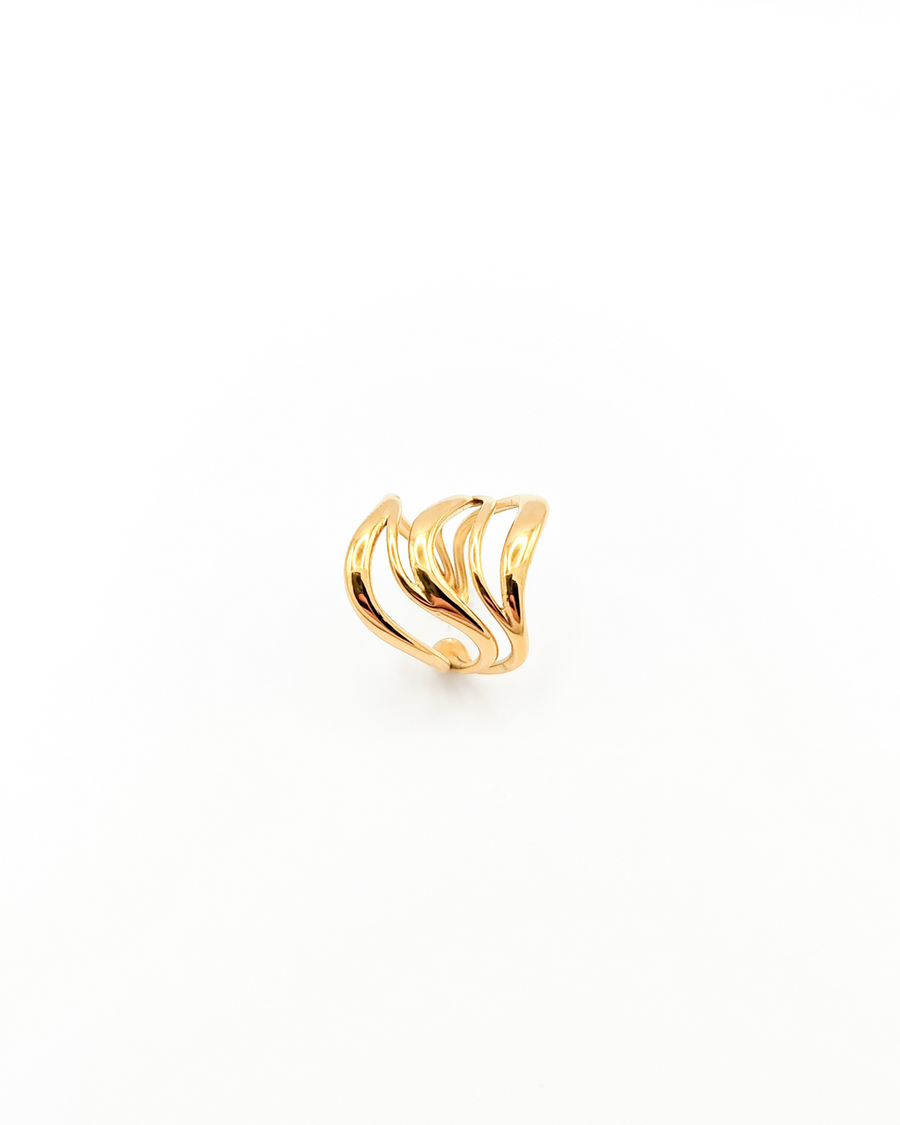 Anello Giulia in acciaio inossidabile color oro. È fotografato rivolto verso l'alto. Si vede il design a onde con il ricciolo sul lato inferiore, verso la chiusura.