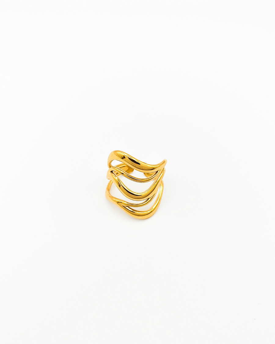 Anello Giulia in acciaio inossidabile color oro. È fotografato frontalmente. Si vede il design a onde e la chiusura regolabile sul retro.
