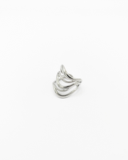 Anello Giulia in acciaio inossidabile color argento. È fotografato appoggiato su un lato in 3/4. Si vede il design a onde con il ricciolo sul lato inferiore, verso la chiusura.