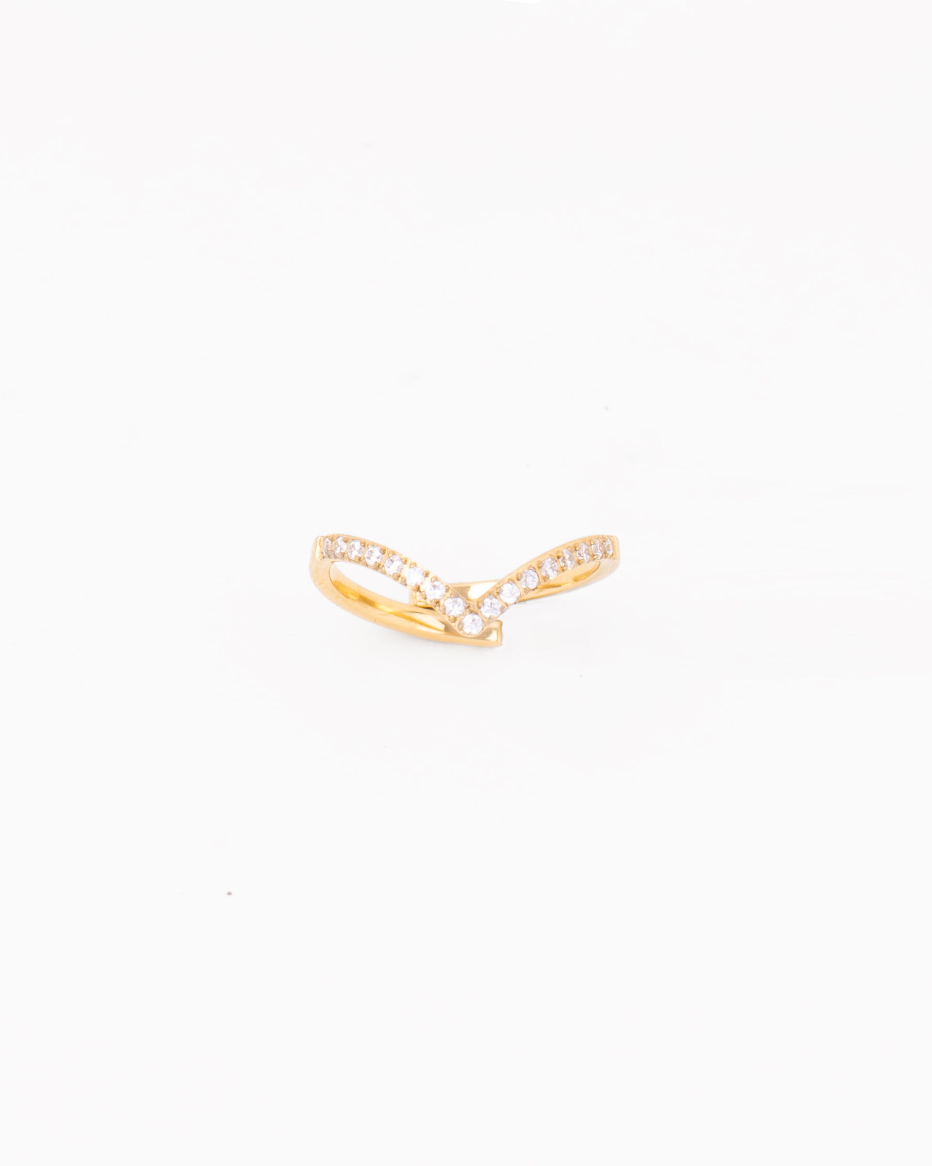 Anello modello Ilaria. È una fedina di color oro, appuntita al centro e decorata con strass luminosi e realizzata in acciaio inossidabile, anallergico e waterproof. È fotografata frontalmente per mettere in risalto la forma a punta.