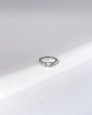 Anello Letizia in acciaio inossidabile anallergico in colore argento e zirconi. La pietra centrale è accompagnata da piccole pietre sui lati. E' rappresentato frontalmente su uno sfondo grigio.