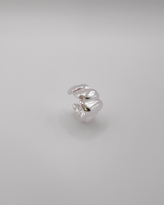 Anello Michelle in acciaio inossidabile color argento. Ha una lavorazione trasversale che ricorda i croissant. E' ripreso in tre quarti da sopra.