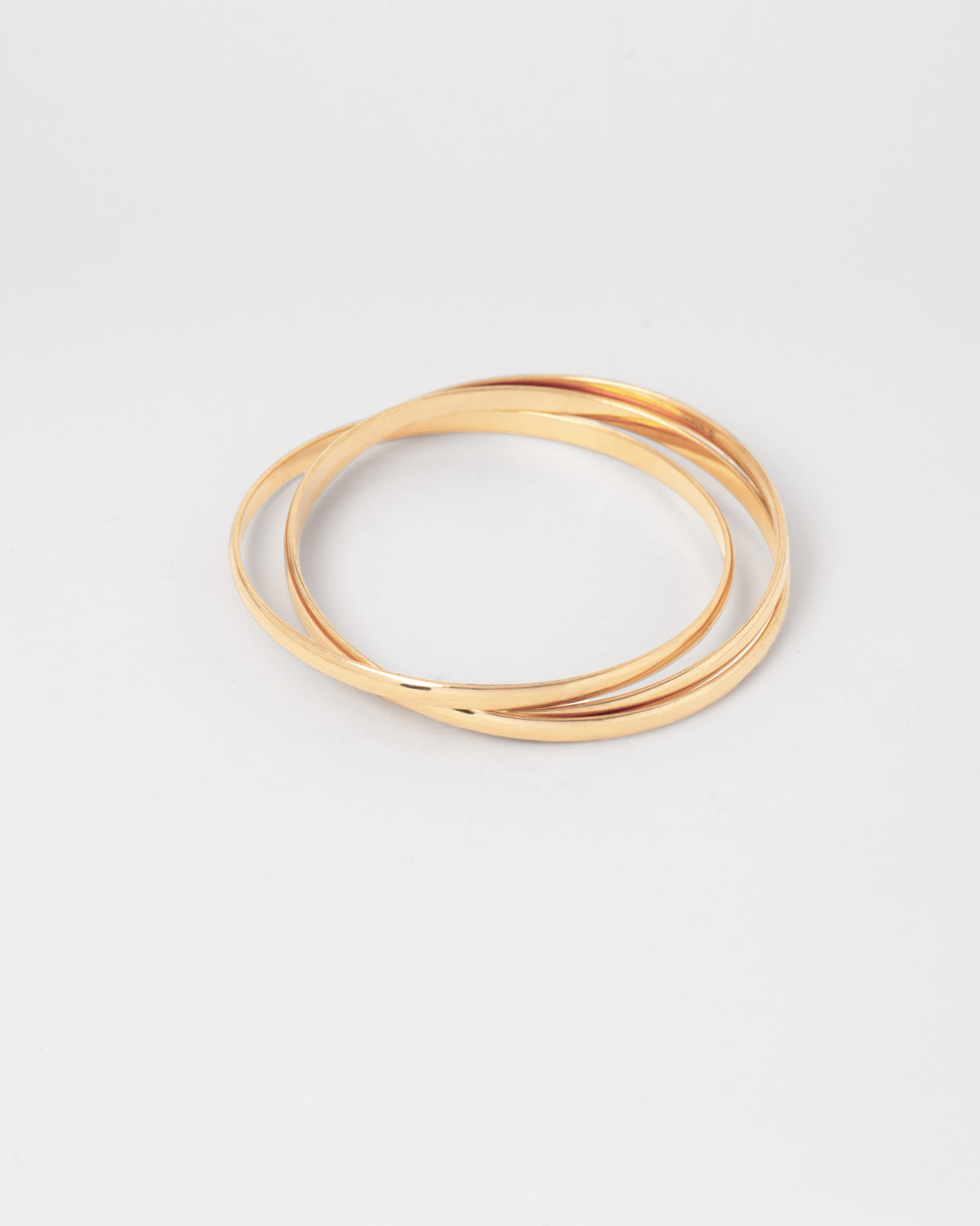 Bracciale rigido Paola in acciaio inossidabile color oro, composto da tre bracciali distinti intrecciati tra loro. Qui viene rappresentato chiuso e si nota l'intreccio. Come sempre è in materiale anallergico e waterproof.