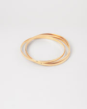 Bracciale rigido Paola in acciaio inossidabile color oro, composto da tre bracciali distinti intrecciati tra loro. Qui viene rappresentato chiuso e si nota l'intreccio. Come sempre è in materiale anallergico e waterproof.