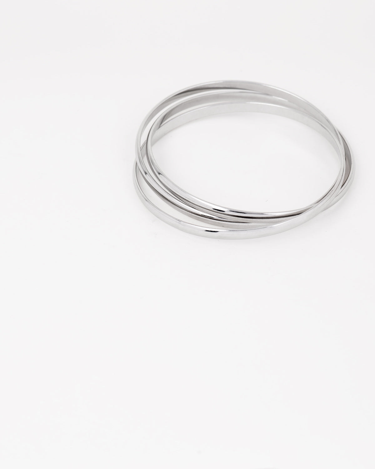 Bracciale rigido Paola in acciaio inossidabile color argento, composto da tre bracciali distinti intrecciati tra loro. Qui viene rappresentato chiuso e si nota l'intreccio. Come sempre è in materiale anallergico e waterproof.