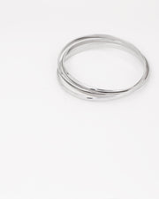 Bracciale rigido Paola in acciaio inossidabile color argento, composto da tre bracciali distinti intrecciati tra loro. Qui viene rappresentato chiuso e si nota l'intreccio. Come sempre è in materiale anallergico e waterproof.