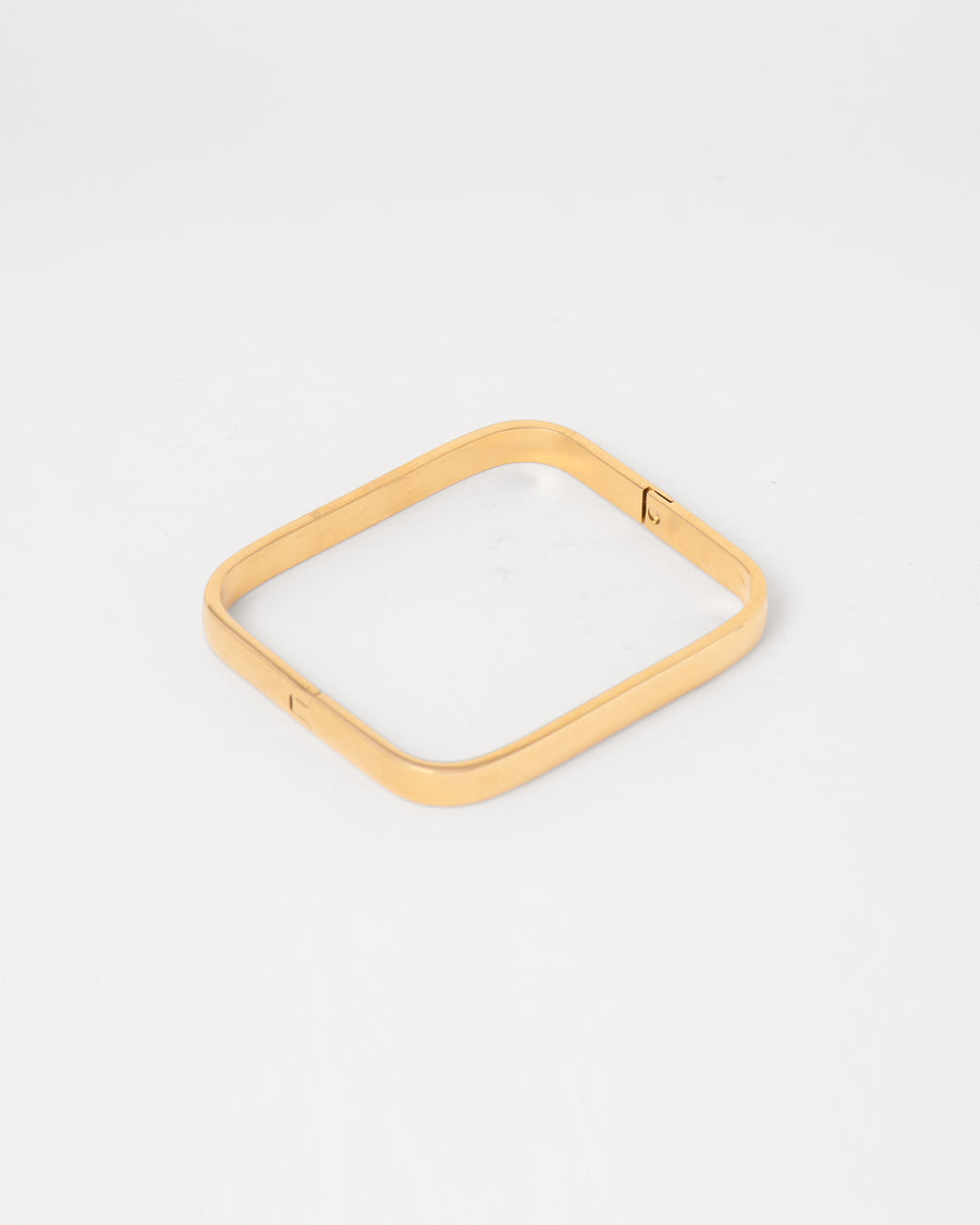 Bracciale rigido Valentina in acciaio inossidabile color oro. È rappresentato chiuso e disteso su uno sfondo chiaro. La forma è rettangolare e la chiusura è a scomparsa. È prodotto in materiale resistente all'acqua e anallergico.