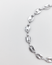 Bracciale Elena in acciaio inossidabile anallergico e waterproof color argento. E' composto da tanti ciondoli ovali legati a catena. E' regolabile e rappresentato su uno sfondo grigio chiaro.