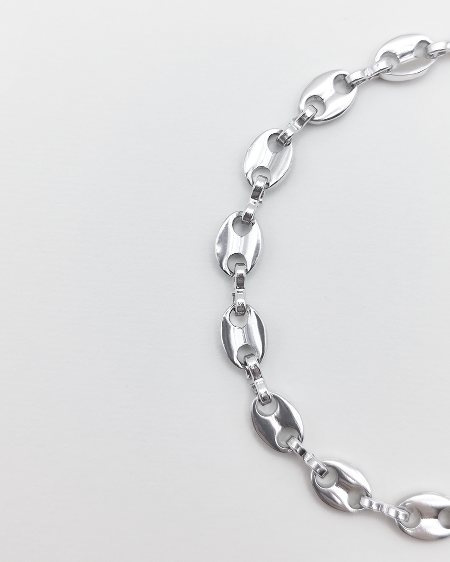 Bracciale Elena in acciaio inossidabile anallergico e waterproof color argento. E' composto da tanti ciondoli ovali legati a catena. E' regolabile e rappresentato su uno sfondo grigio chiaro.