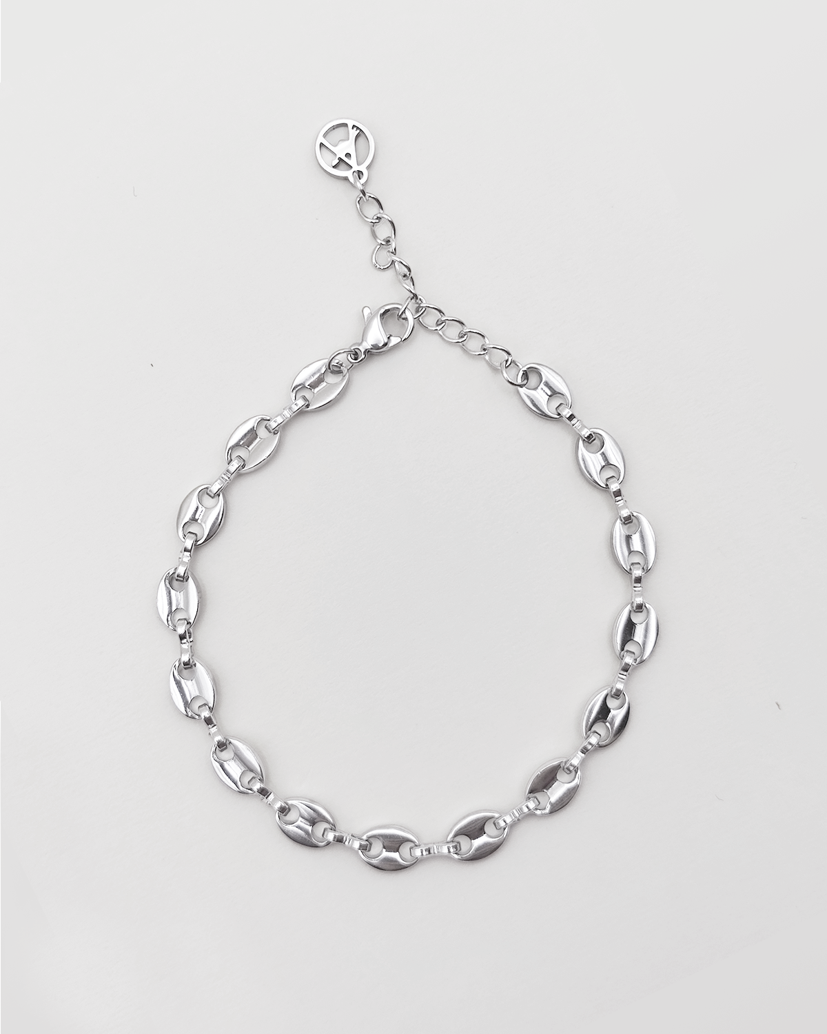 Bracciale Elena in acciaio inossidabile anallergico e waterproof color argento. E' composto da tanti ciondoli ovali legati a catena. E' regolabile e rappresentato su uno sfondo grigio chiaro.