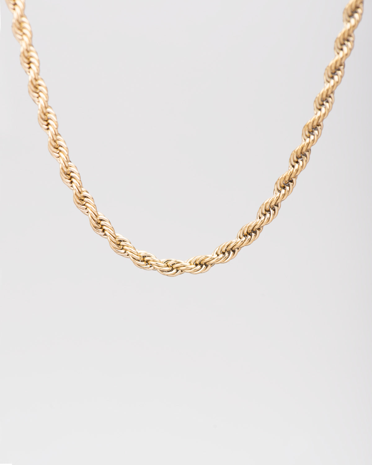 Collana Ester in acciaio inossidabile color oro, modello torchon. È raffigurata appesa su sfondo chiaro. Si notano bene le maglie intrecciate.