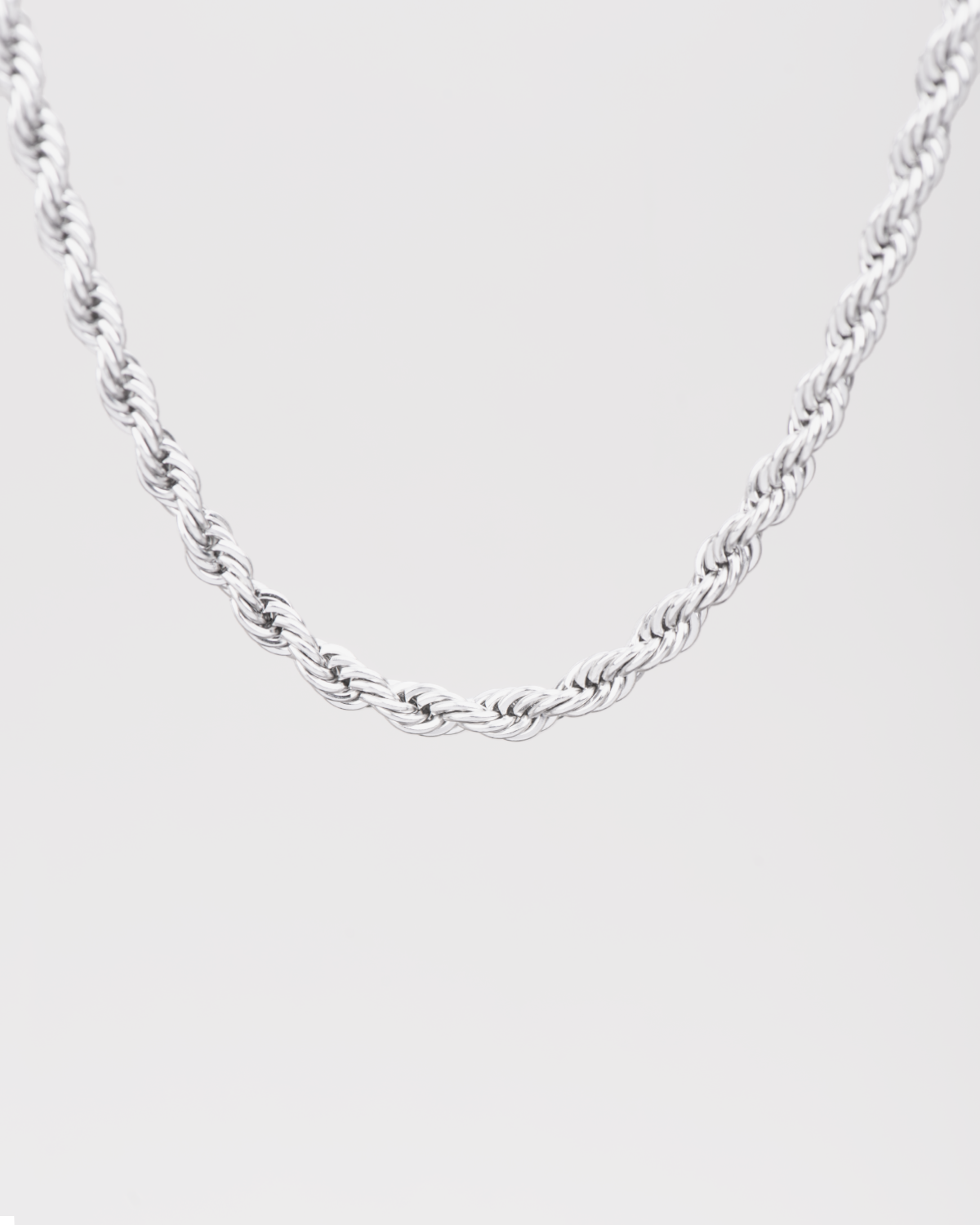 Collana Ester in acciaio inossidabile color argento, modello torchon. È raffigurata appesa su sfondo chiaro. Si notano bene le maglie intrecciate.