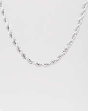 Collana Ester in acciaio inossidabile color argento, modello torchon. È raffigurata appesa su sfondo chiaro. Si notano bene le maglie intrecciate.