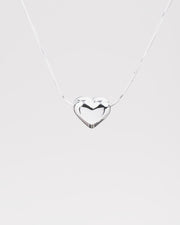 Dettaglio sul cuore bombato in acciaio inossidabile della collana Jessica nella versione argento. Il finish è molto lucido e la catenina molto sottile e fine.