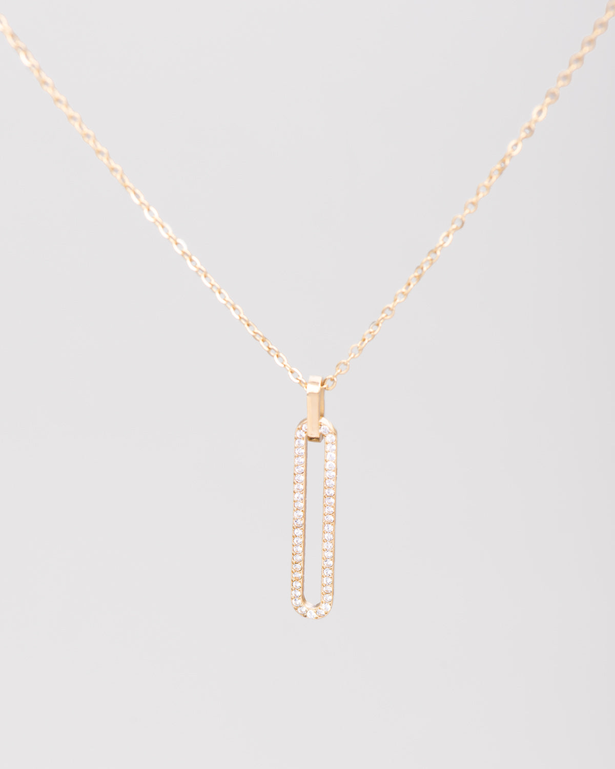 Collana Lorena in acciaio inossidabile color oro e pendente ovale. Il ciondolo è di dimensioni ridotte e ricoperto da una fila di strass luminosi. La catenina è semplice e molto raffinata.