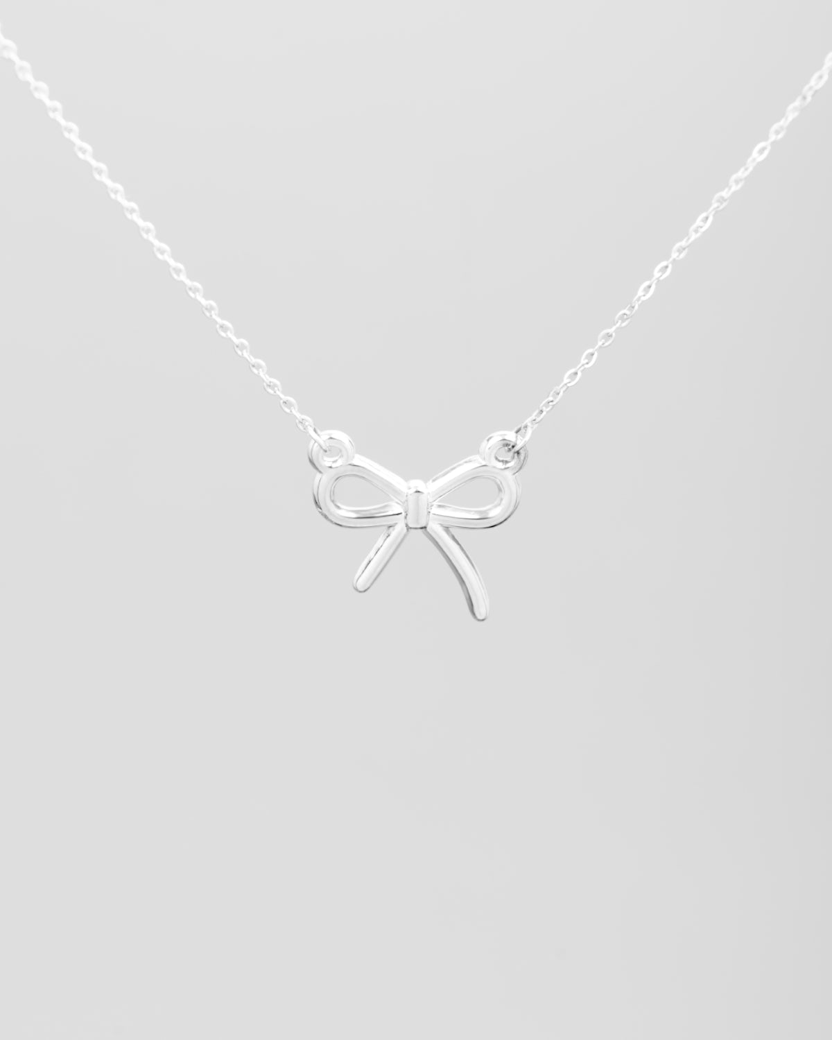 Collana Pamela in acciaio inossidabile color argento. Al centro, sorretto da due anellini tondi, si trova un fiocchetto in acciaio dal finish lucido.