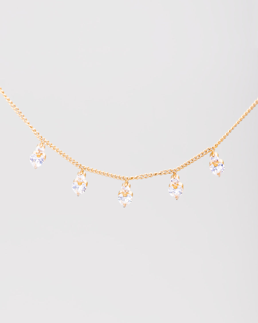 Collana Stefania in acciaio inossidabile color oro e pendenti a forma di cuore in strass. Dalla catenina pendono 5 cuoricini luminosi, sormontati a loro volta da un piccolo brillantino.