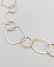 Dettaglio della Collana Liliana in acciaio inossidabile e anallergico, formata da tanti ciondoli di diverse forme geometriche. Molto fine ed elegante, è ripresa su uno sfondo grigio chiaro.