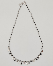 Collana Marta in acciaio inossidabile anallergico color argento. È decorata con charms a forma di cuoricino, cristalli neri e perle di fiume. Sulla chiusura c'è una catenella che permette di regolarne la lunghezza
