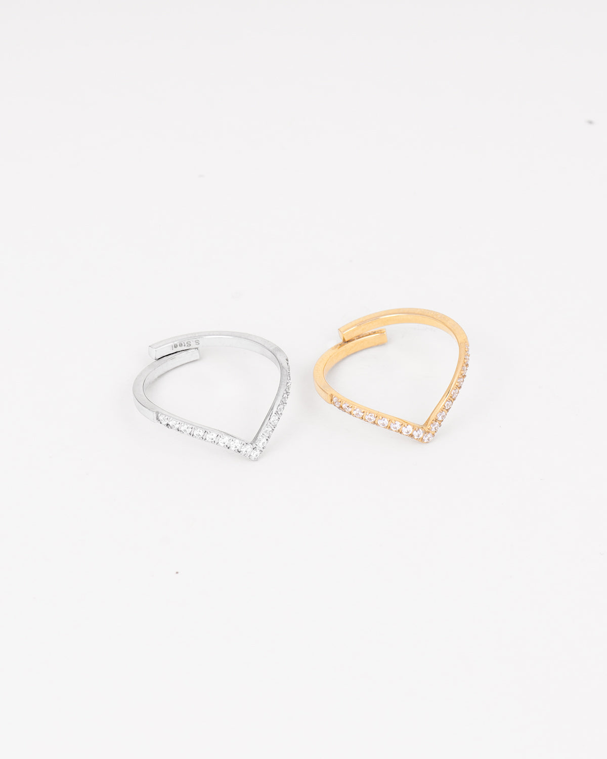 Coppia di anelli Ilaria, due fedine sottili dalla forma appuntita e coperti di strass nella parte frontale. Sono affiancati e presentati nelle due colorazioni oro e argento. È ben visibile la regolazione sul retro ed il materiale è anallergico e resistente all'acqua.