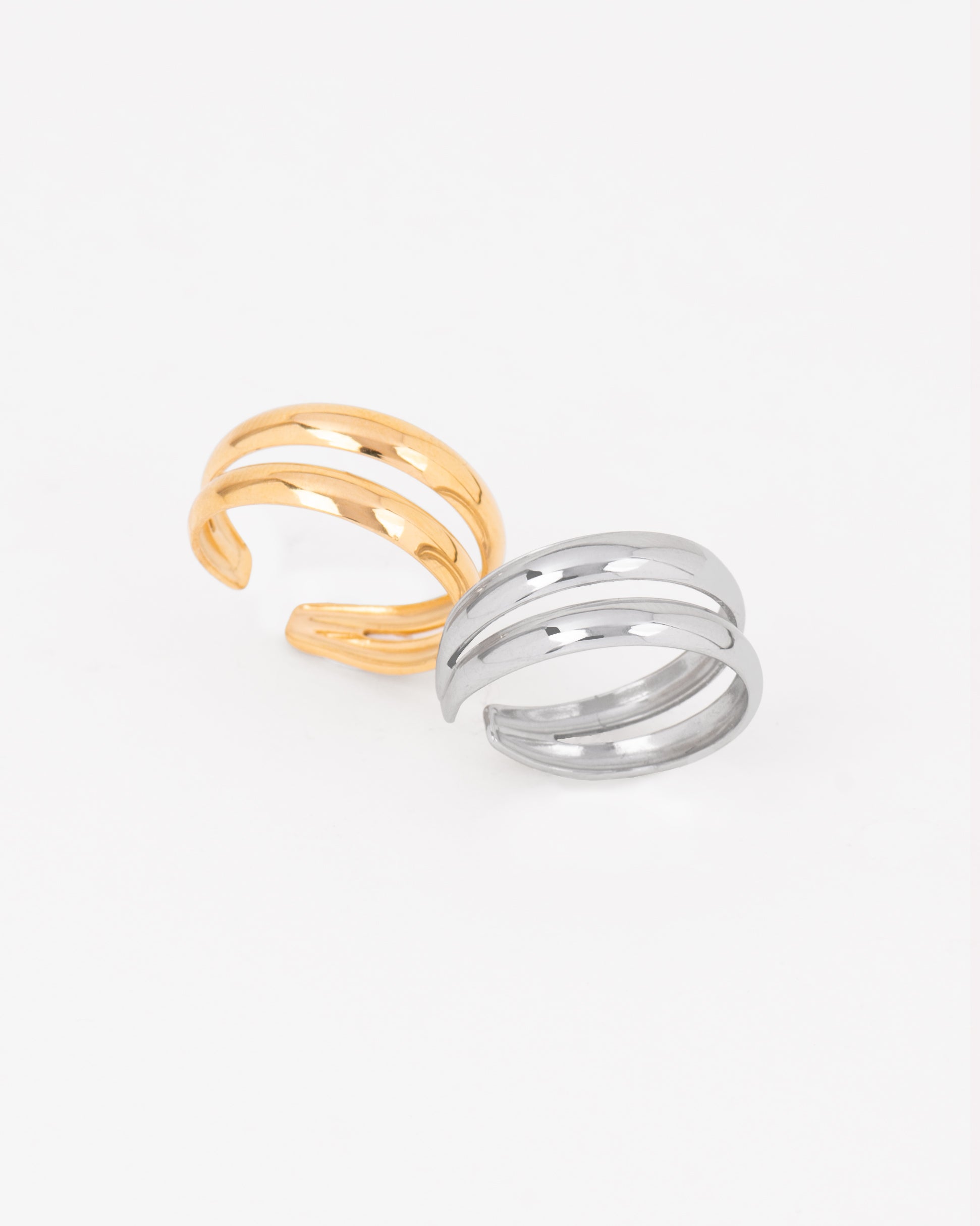 Coppia di anelli Paola in acciaio inossidabile in colore oro e argento. Hanno un design a doppio filo unito alle due estremità e sono regolabili. Sono realizzati in materiale anallergico e resistente all'acqua.