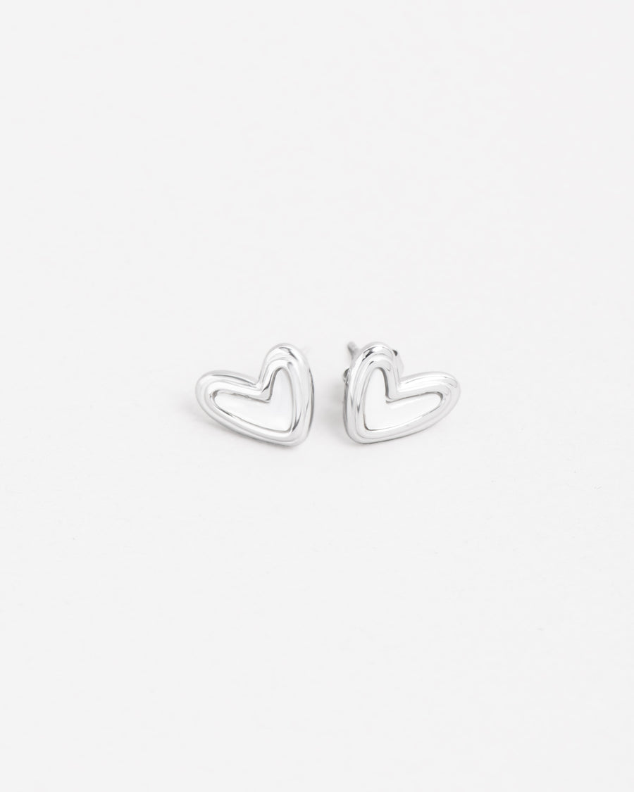 Orecchini Linda in acciaio inossidabile color argento e madreperla e forma a cuore irregolare. Sono rappresentati adagiati sul fianco in posizione speculare.