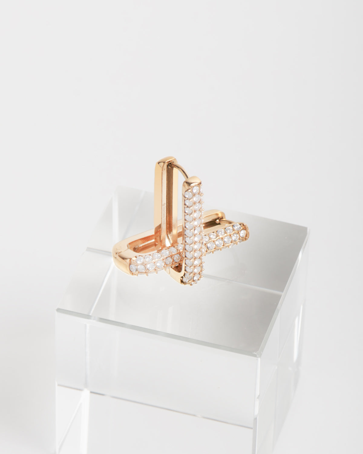 Orecchini in acciaio inossidabile modello Lorena con strass e in colore oro. Sono raffigurati in cima ad un cubo di cristallo. Hanno una forma rettangolare allungata ed hanno tre file di strass sul davanti.