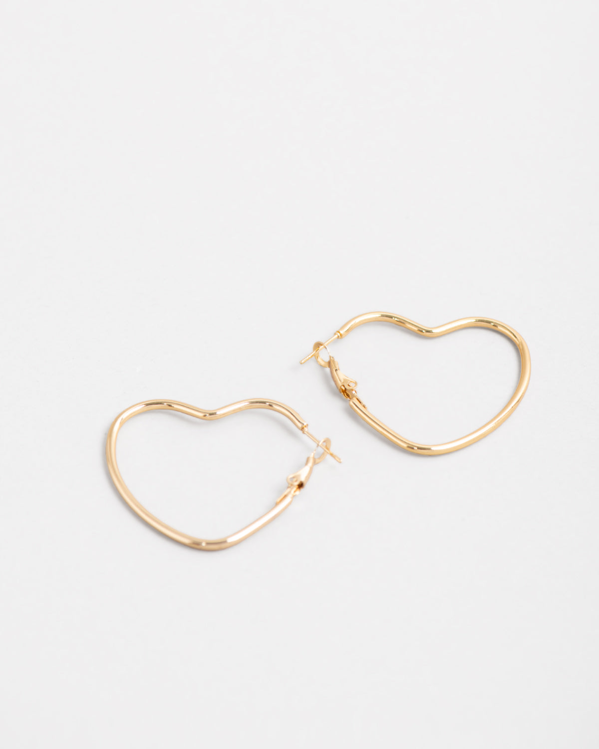 Orecchini Silvia in acciaio inossidabile color oro. Sono un modello a cerchio a forma di cuore ed hanno la chiusura a monachella. Sono rappresentati affiancati e l'orecchino di destra è leggermente più in alto di quello a sinistra.
