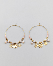 Orecchini Mascia in acciaio inossidabile anallergico color oro. Hanno una forma a cerchio e sono arricchiti da perline e pietre colore rosa e charms dorati.